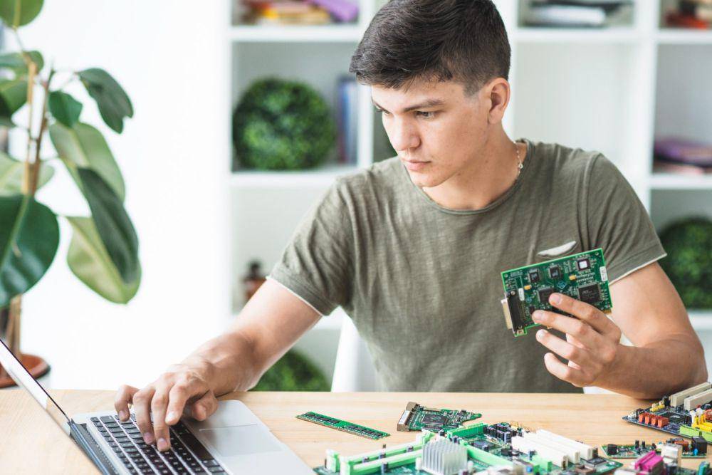 Ilustrasi pria meilhat laptop dan memegang hardware (freepik.com/freepik)