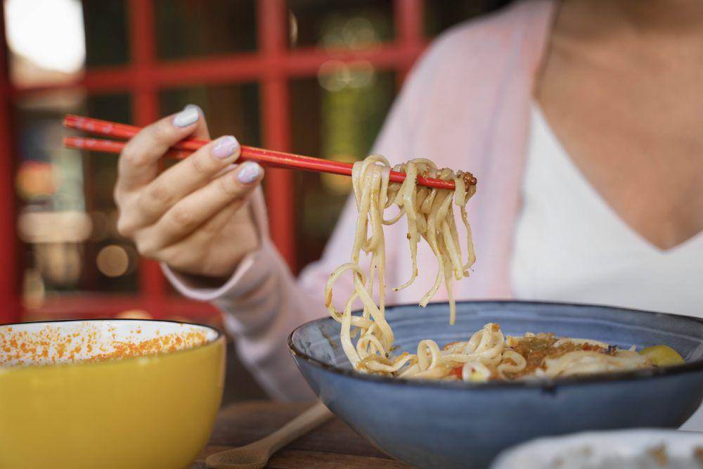Ilustrasi seorang wanita sedang makan bakmi. Freepik