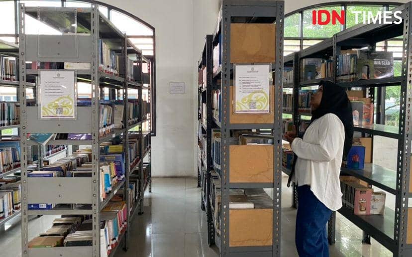 Salah satu pengunjung yang membaca buku didepan Perpustakaan Sumut (IDN Times/Indah Permata Sari)