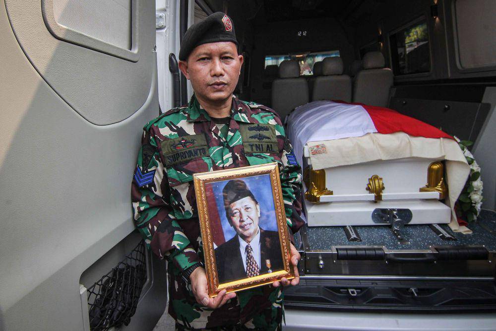 Prajurit TNI memegang foto almarhum Wakil Presiden ke-9 Hamzah Haz di Jalan Tegalan, Matraman, Jakarta, Rabu (24/7/2024). (ANTARA FOTO/Dhemas Reviyanto)