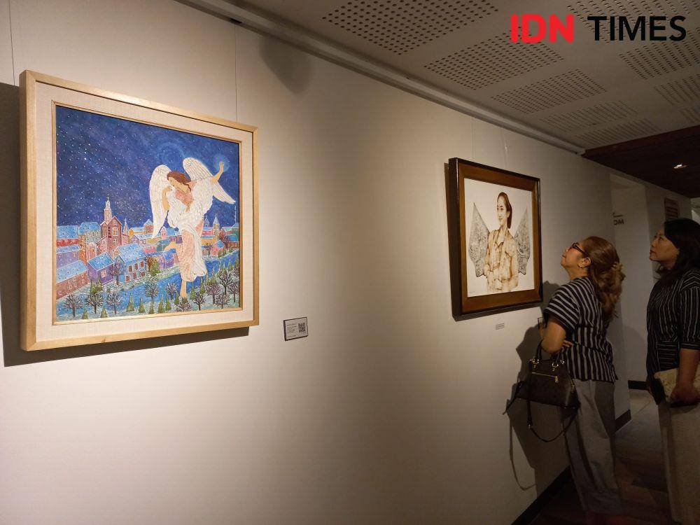 Pengunjung menikmati karya lukis yang dipamerkan (IDN Times/Yogie Fadila)