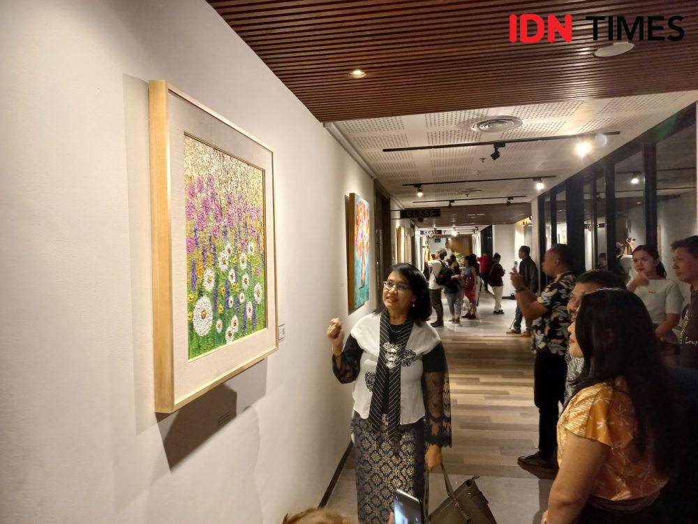 Pengunjung menikmati karya lukis yang dipamerkan (IDN Times/Yogie Fadila)