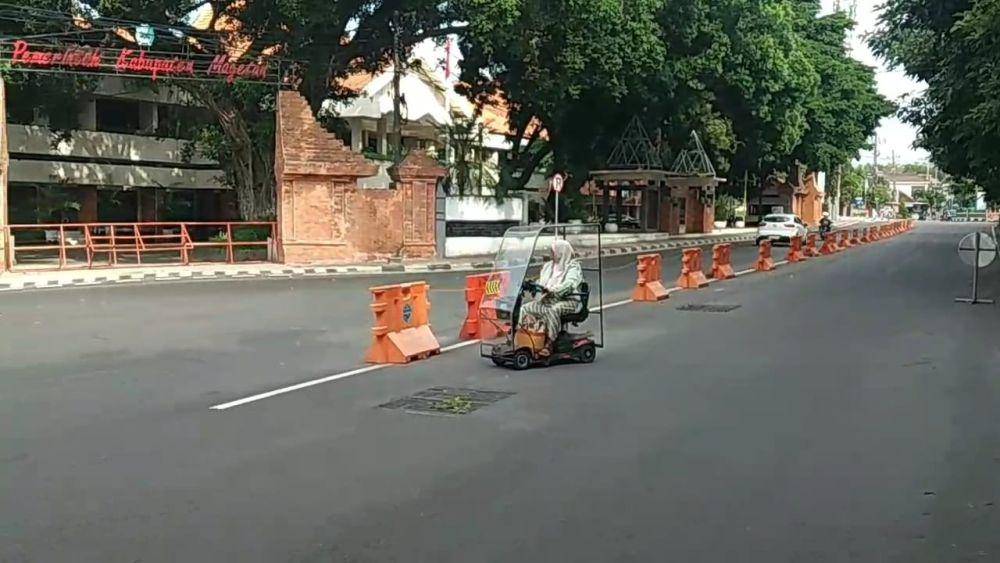 Pengendara motor listri tengah melintas di jalan raya Magatan. IDN Times/ Riyanto.
