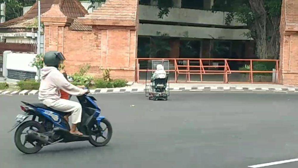 Pengendara motor listri tengah melintas di jalan raya Magatan. IDN Times/ Riyanto.