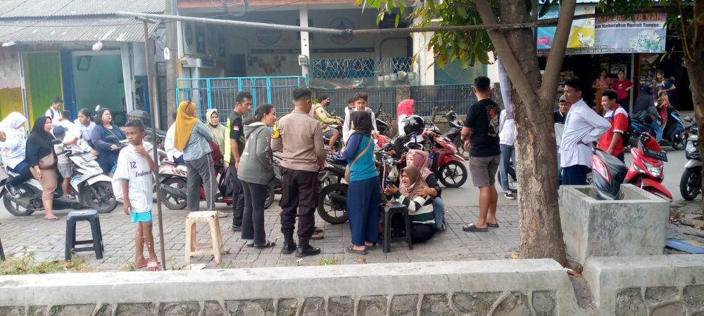 Warga saat menenangkan wanita yang kehilangan anaknya di warung soto. (Dok.Polsek Rawalumbu).