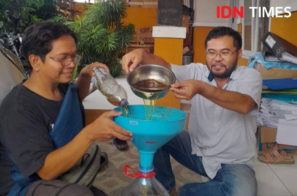 Dika (kiri) saat jemput bola mengambil minyak jelantah ke warga bernama Hanan Wiyoko di Banyumas, Minggu (4/8/2024).(IDN Times/Cokie Sutrisno)