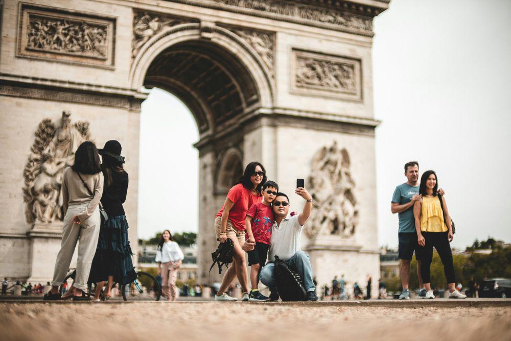 ilustrasi orang berfoto saat liburan (unsplash.com/Mika Baumeister)