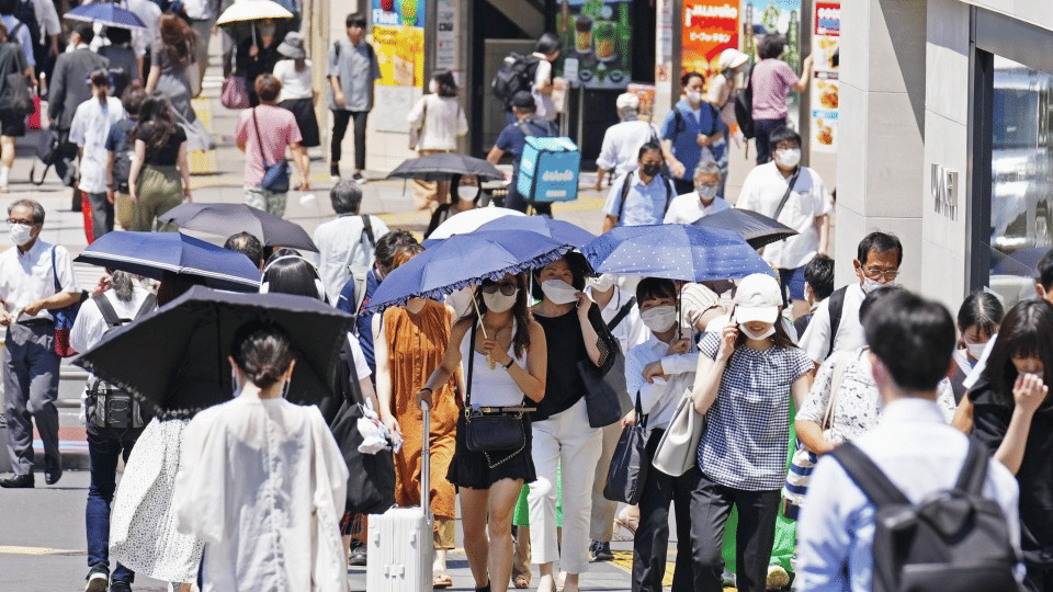 Orang-orang berjalan, dengan beberapa memegang payung, di tengah panas terik di daerah Shinjuku Tokyo pada 28 Juni 2022 (kyodonews.com)