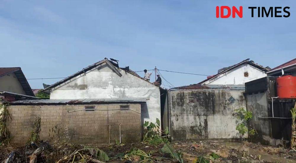Warga mengevakuasi genteng rumah warga yang disapu angin. (IDN Times/Teri).