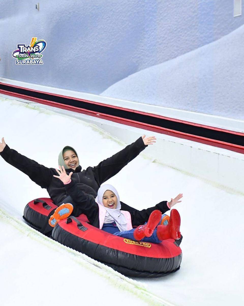 Pengunjung Trans Snow World yang sedang menikmati sensasi meluncur di tengah salju. Instagram/transsnowworld.surabaya
