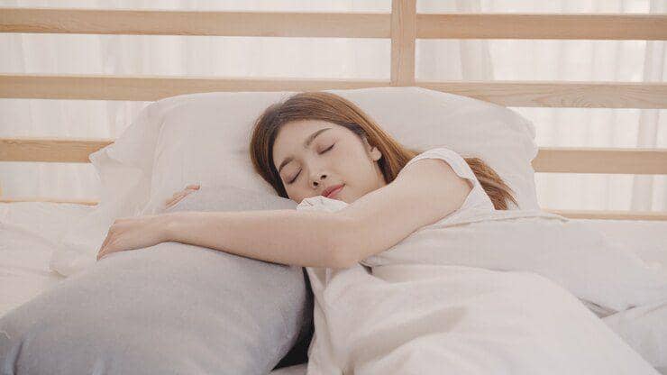 Seorang perempuan tidur posisi miring.