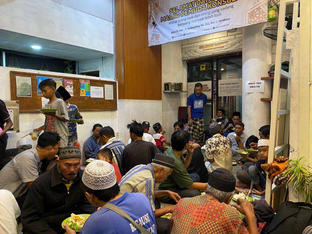 Para pengunjung dan warga sedang menikmati makanan di teras masjid (IDN Times/Ryzka Tiara)