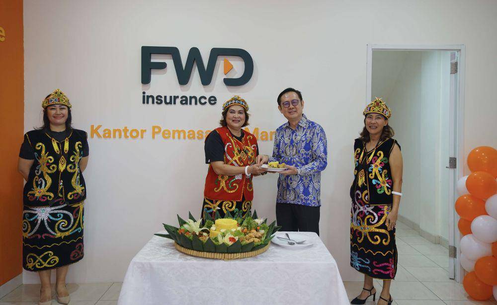 Keterangan foto (tengah) Djulinda Artati (Financial Wealth Director FWD Insurance) menyerahkan potongan tumpeng kepada Jeffrey Kie (Chief Agency Officer FWD Insurance). (Istimewa)