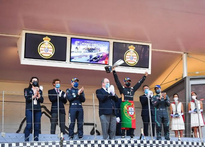 Antonio Felix da Costa (tengah) mengangkat trofi kemenangan E-Prix Monako 2021 diikuti Robin Frijns (kiri) di podium kedua dan Mitch Evans (kanan) di podium ketiga. (fiaformulae.com)