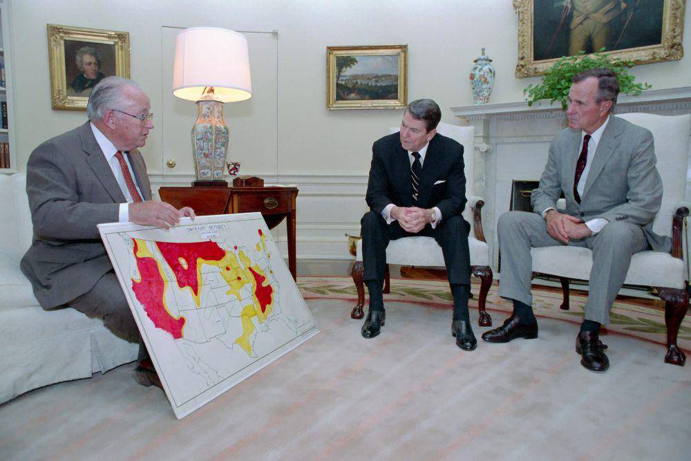 Presiden Ronald Reagan dan Wakil Presiden Bush di Ruang Oval saat sedang membahas situasi kekeringan dan gelombang panas dengan Richard Lyng, pada (17/6/1988). (commons.wikimedia.org/Reagan White House Photographs)