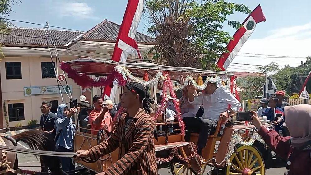 Pasangan Nanik Endang Rusminiarti dan Suyatni Priasmoro menaiki dokar pendaftaran ke KPU Magetan. IDN Times/ Riyanto.