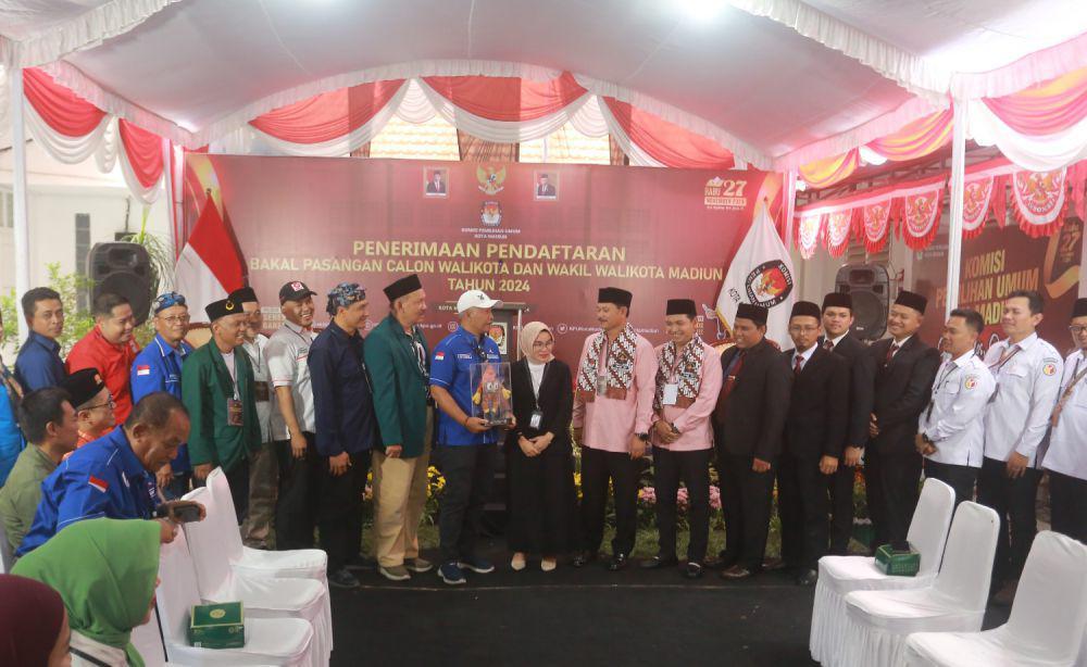 Kenakan baju pink, pasangan bakal calon Walikota wakil Walikota Madiun Maidi-Bagus Panuntun mendaftar ke KPU. IDN Times/ Istimewa.
