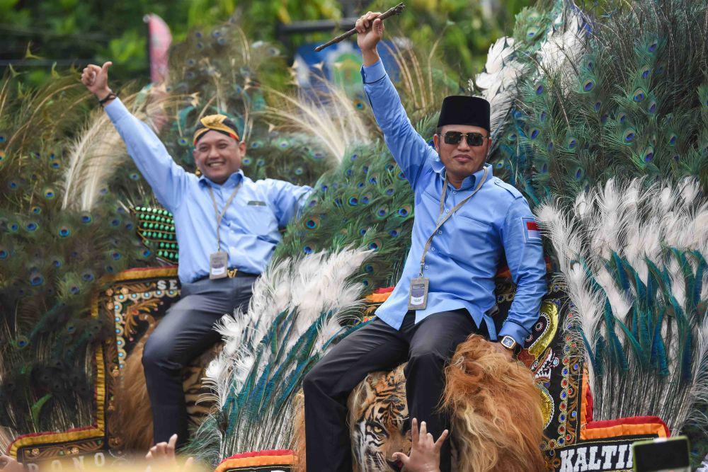 Pasangan bakal calon Gubernur Kalimantan Timur Rudy Mas'ud (kanan) dan bakal calon Wakil Gubernur Seno Aji (kiri) melambaikan tangannya di atas kepala Reog Ponorogo saat menuju Komisi Pemilihan Umum (KPU) Provinsi Kaltim, Samarinda, Kamis (29/8/2024). (ANTARA FOTO/M Risyal Hidayat)