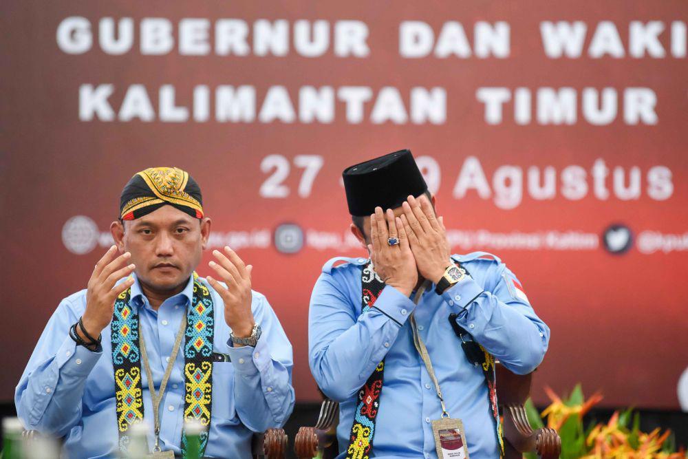 Pasangan bakal calon Gubernur Kalimantan Timur Rudy Mas'ud (kanan) dan bakal calon Wakil Gubernur Seno Aji (kiri) berdoa saat mendaftar di Komisi Pemilihan Umum (KPU) Provinsi Kaltim, di Samarinda, Kamis (29/8/2024). (ANTARA FOTO/M Risyal Hidayat)