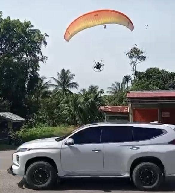 Tangkap layar video warga saat atlet paramotor PON 2024 mendarat darurat di permukiman warga.