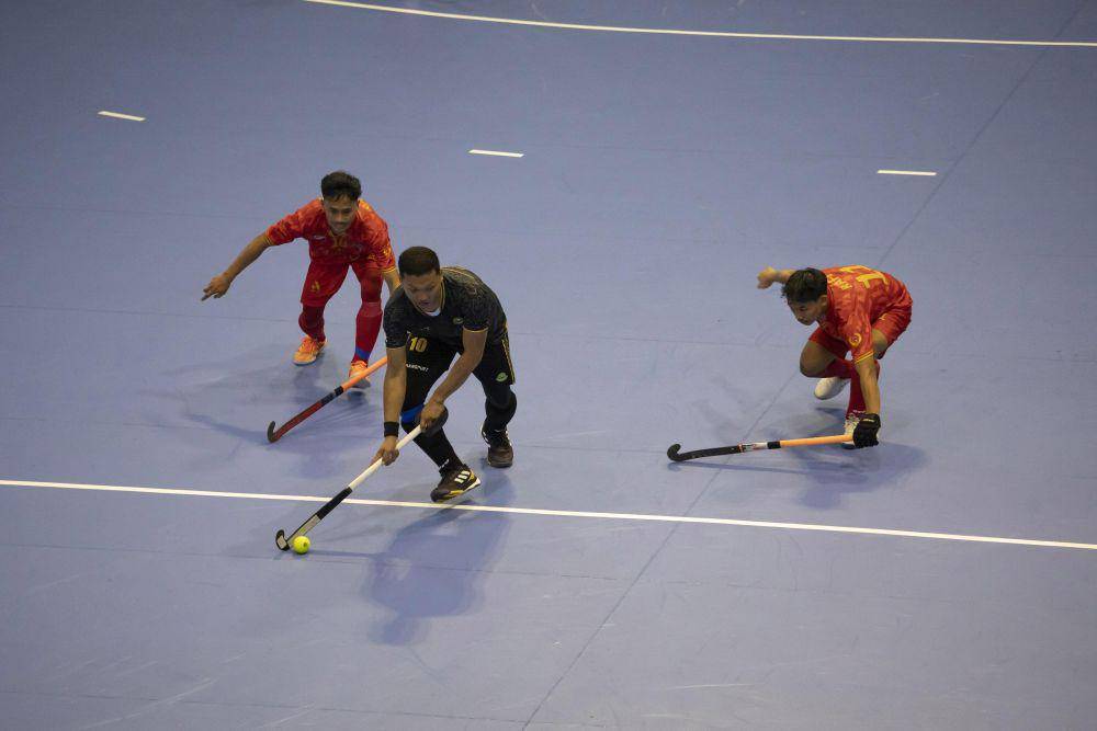 Atlet hoki indoor putra Jawa Barat Prima Rinaldi Santoso (hitam) dibayang-bayangi dua pemain Jawa Tengah pada pertandingan penyisihan hoki indoor putra PON XXI Aceh Sumut yang berlangsung di Gedung Serbaguna Unimed Deliserdang, Selasa (03/09/24). (PB PON XXI ACEH SUMUT / M. Zulfan Dalimunthe)