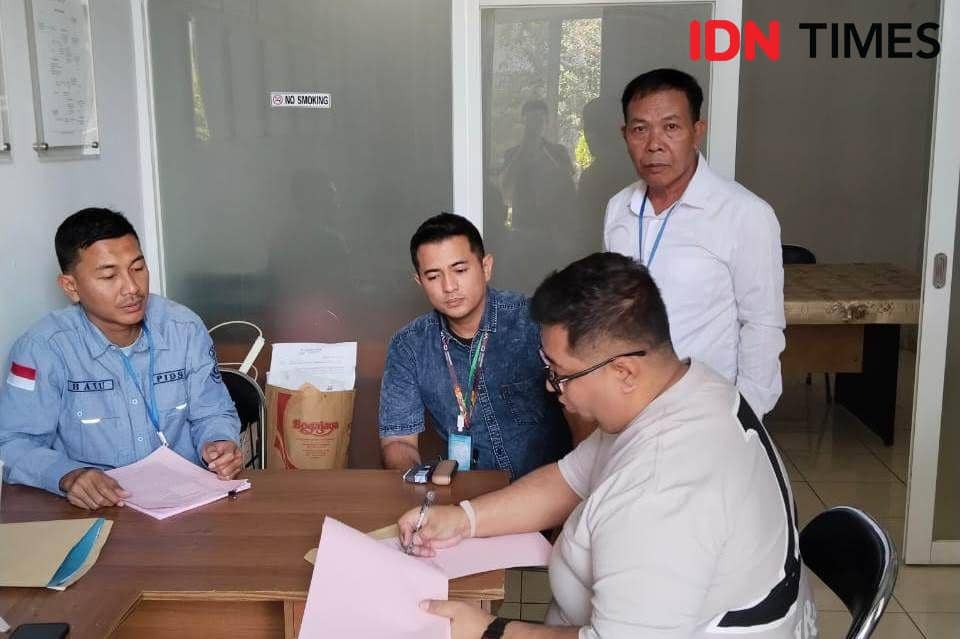 Tersangka HY berkacamatan didampingi petugas kejaksaan menandatangi serah terima tersangka dan barang bukti (IDN Times/Ervan)