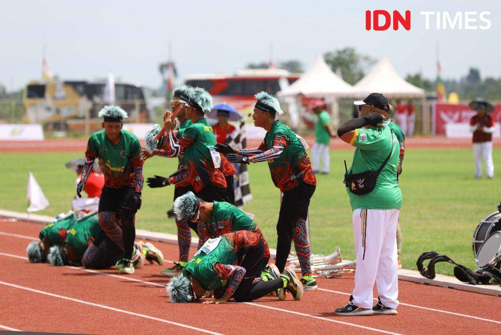 Tim drumband putra Sumatra Utara memberikan penghormatan kepada penonton usai menuntaskan nomor Lomba Berbaris Jarak Pendek (LBJP) 400 meter  di ajang Pekan PON XXI Aceh-Sumut di Sport Centre, Deliserdang, Sumatra Utara, Minggu (8/9/2024). (IDN Times/Prayugo Utomo)