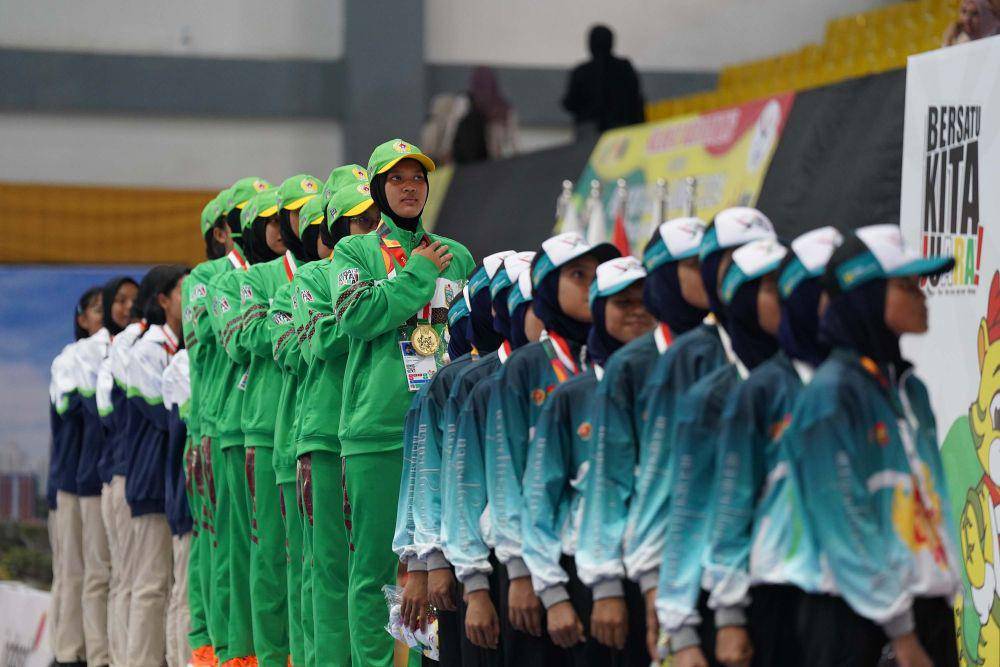 Tim drumband Sumatera Utara menyanyikan lagu Bagimu Negeri usai berhasil meraih medali emas pada nomor Lomba Berbaris Jarak Pendek (LBJP) 600 Meter mix di ajang PON XXI Aceh-Sumut di GOR Futsal Disporasu, Deliserdang, Sumatra Utara, Senin (9/9/2024). (PB PON XXI ACEH-SUMUT/Mirza Baihaqie)