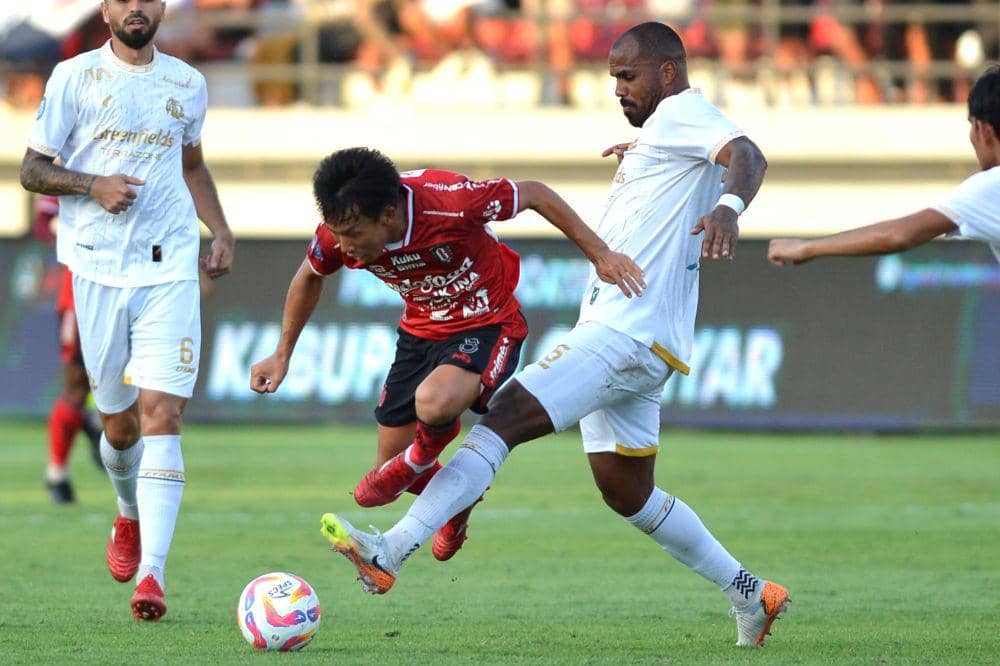 Pesepak bola Bali United Mitsuru Maruoka (merah) berusaha melewati hadangan pesepak bola Arema FC Thales Natanael Lira De Matos (putih) dalam pertandingan Liga 1 2024/2025 di Stadion Kapten I Wayan Dipta Gianyar, Bali, Rabu (11/9/2024). ANTARA FOTO/Fikri Yusuf/nym.
