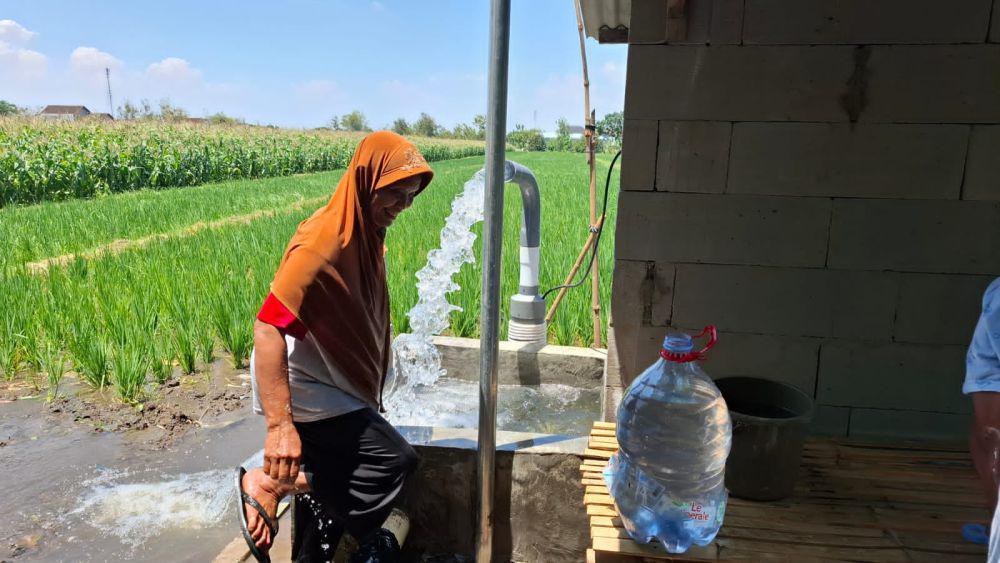 Warga mengambil air dari sumur persawahan desa tetangga. IDN Times/ Riyanto.