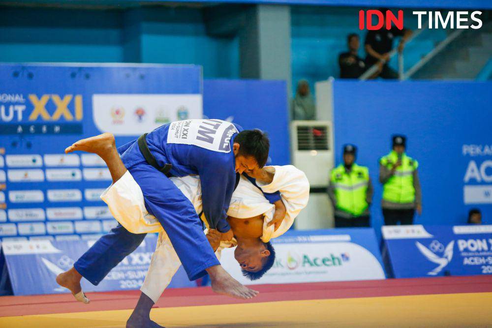 Pejudo Sumut Winner Felix Panggabean (putih) saat berlaga di kelas beregu campuran PON 2024 di Gor Universitas Syiah Kuala, Banda Aceh, Sabtu (14/9/2024) (IDN Times/Doni Hermawan)