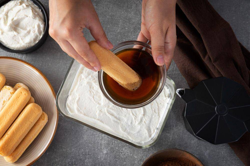 ilustrasi mencelupkan ladyfinger pada kopi