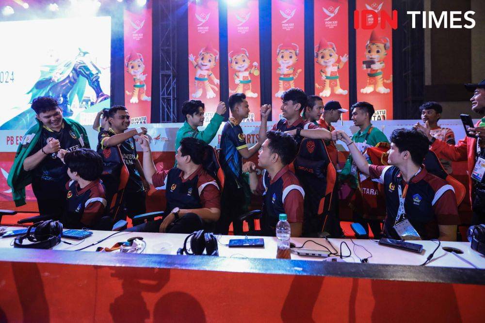 Tim Esports Sumatra Utara berjabat tangan dengan tim Bali setelah memenangkan laga Grand Final Mobile Legend Pekan Olahraga Nasional (PON) 2024, Rabu (18/9/2024) malam. (IDN Times/Prayugo Utomo)