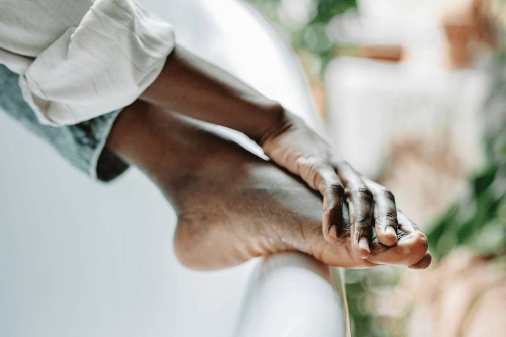 Potret pria sedang mengoleskan pelembap kaki (pexels.com/@roman-odintsov)
