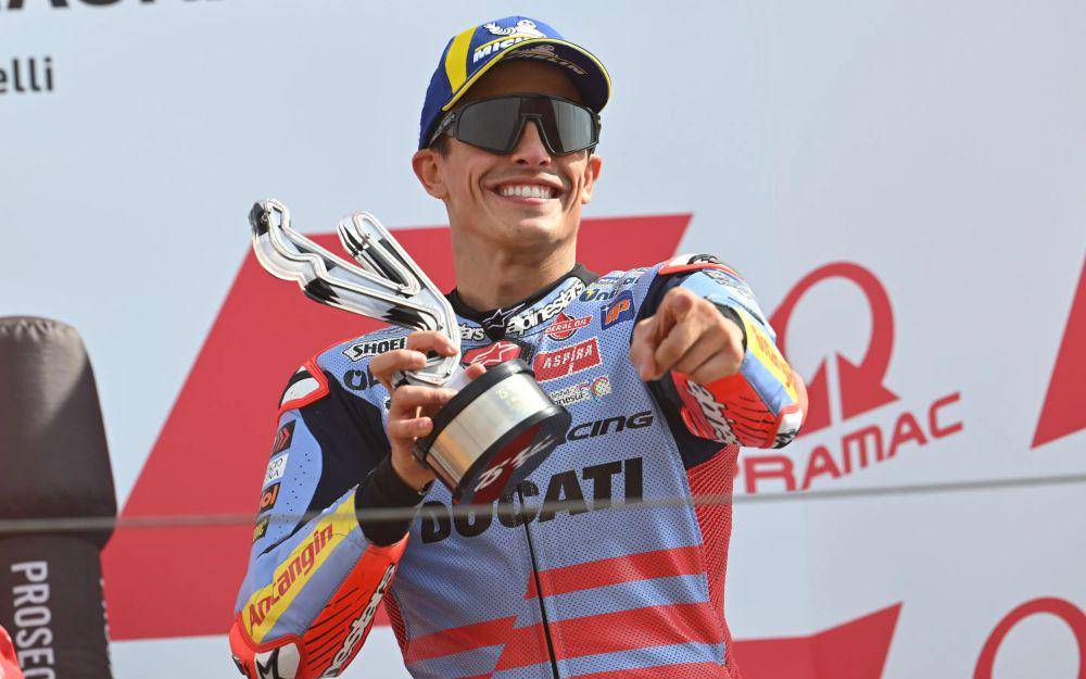 Marc Marquez mengangkat trofi usai finis ketiga di grand prix race GP Emilia Romagna 2024. (motogp.com)