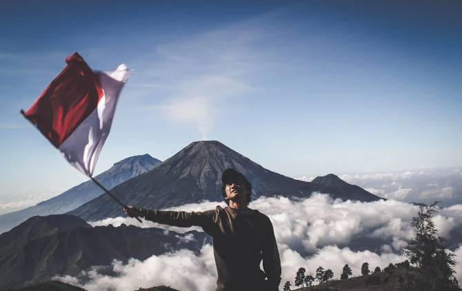 ilustrasi pendaki gunung memegang bendera merah putih (pexels.com/diohasbi)