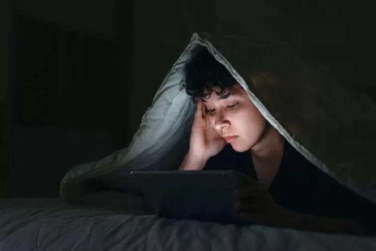 Seorang pria begadang sambil bermain gadget (pinterest.com)