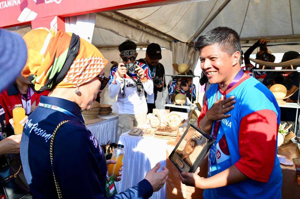 Direktur Utama Pertamina Nicke Widyawati saat menerima karya lukisan wajah yang dibuat dari pelepah kelapa dari Good Craft yang merupakan UMKM binaan Pertamina. (dok. Pertamina)