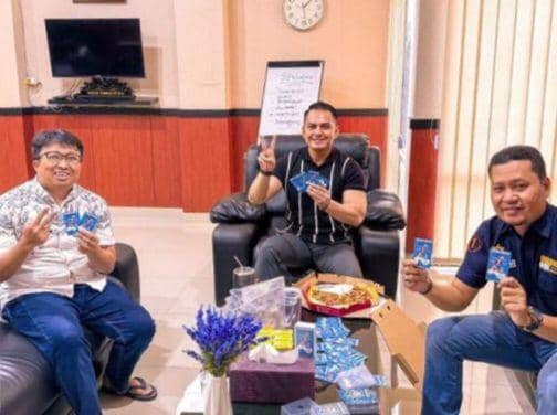 Foto yang menampilkan ketiga ASN Pemprov Sulsel memamerkan kartu nama salah satu paslon Pilgub Sulsel. (Dok. Istimewa)