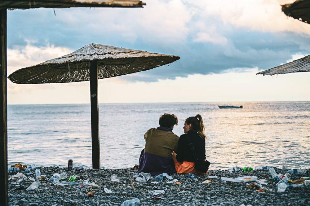 ilustrasi pasangan sedang duduk di tepi pantai yang kotor (pexels.com/Alexander Nadrilyanski)