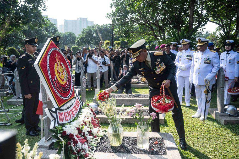 Panglima TNI Jenderal TNI Agus Subiyanto (tengah) menaburkan bunga di makam Presiden ke-3 RI BJ Habibie dalam saat nasional di Taman Makam Pahlawan Nasional Utama Kalibata, Jakarta, Jumat (4/10/2024). (ANTARA FOTO/Aprillio Akbar)