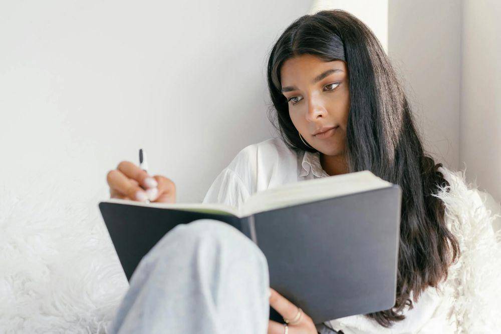 potret seorang wanita sedang menulis (pexels.com/Mikhail Nilov)