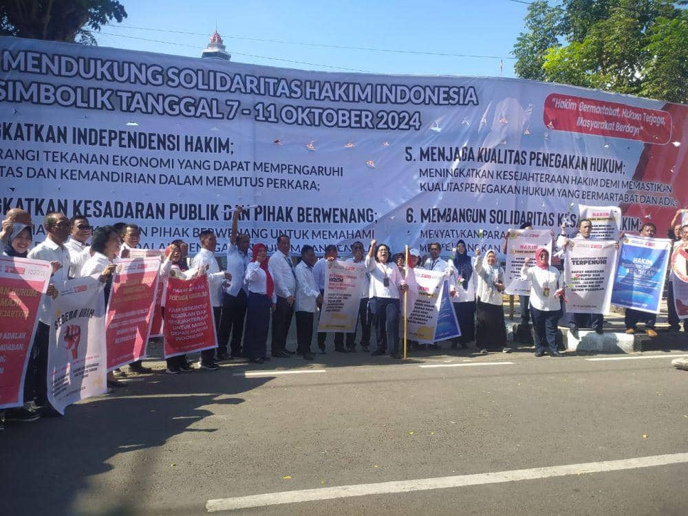 Hakim PN Makassar saat berdiri di depan spanduk tuntutan di PN Makassar, Senin (7/10/2024) / istimewa