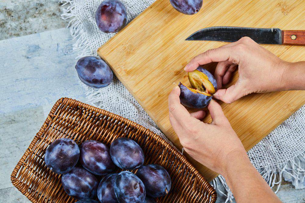 ilustrasi memotong buah plum (freepik.com/azerbaijan-stockers)