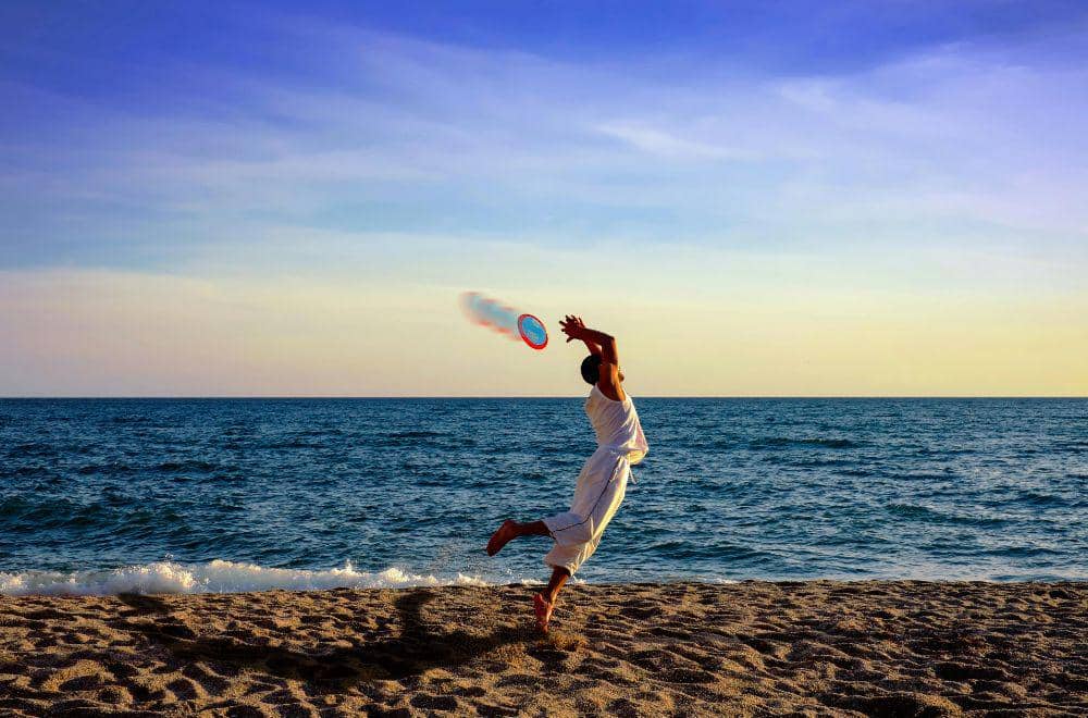 ilustrasi bermain frisbee di pantai (pexels.com/michaelgane)