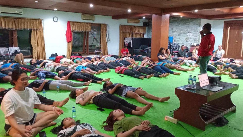 John Seran (berdiri) saat memberikan Terapi Hypnosport kepada kontingen Bali di PON 2024 Aceh-Sumut. (dok.Pribadi/John Seran)