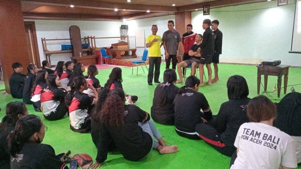 John Seran (berdiri baju kuning) saat memberikan Terapi Hypnosport kepada kontingen Bali di PON 2024 Aceh-Sumut. (dok.Pribadi/John Seran)