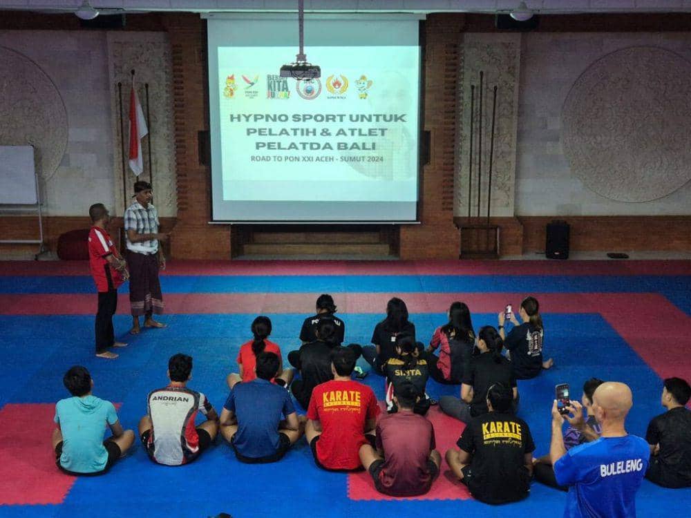 John Seran (berdiri baju merah) saat memberikan Terapi Hypnosport kepada kontingen Bali di PON 2024 Aceh-Sumut. (dok.Pribadi/John Seran)