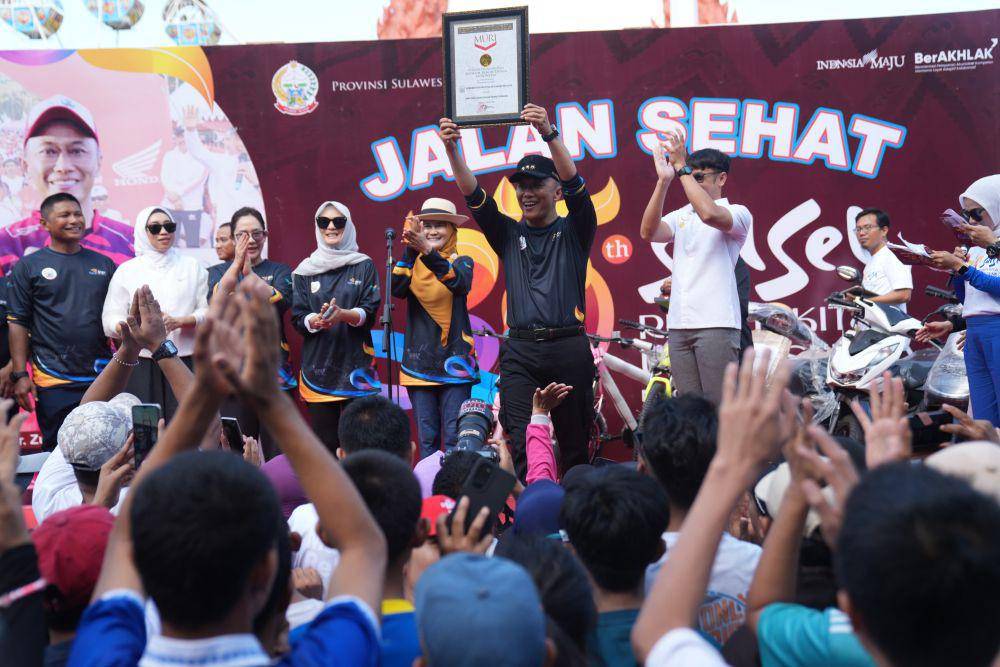 Pj Gubernur Sulawesi Selatan Zudan Arif Fakrulloh menerima piagam rekor MURI jalan santai dengan peserta terbanyak, Minggu (13/10/2024). (Dok. Humas Pemprov Sulsel)