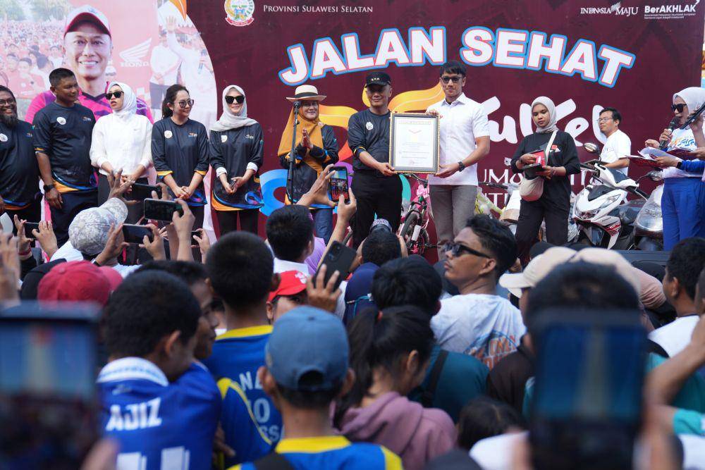 Pj Gubernur Sulawesi Selatan Zudan Arif Fakrulloh menerima piagam rekor MURI jalan santai dengan peserta terbanyak, Minggu (13/10/2024). (Dok. Humas Pemprov Sulsel)